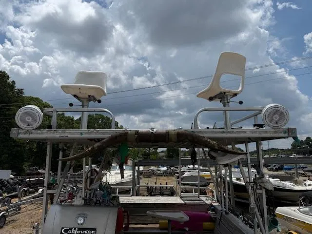 Slide: The Image of 1998 Crest III 25 boat with dual seats and speakers under cloudy sky. - 12
