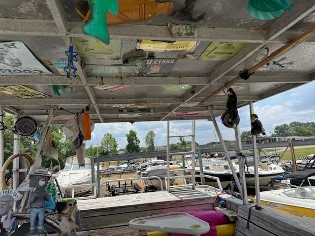 Slide: The Image of Interior of a 1998 Crest III 25 boat with eclectic decorations and docked boats in the background. - 13
