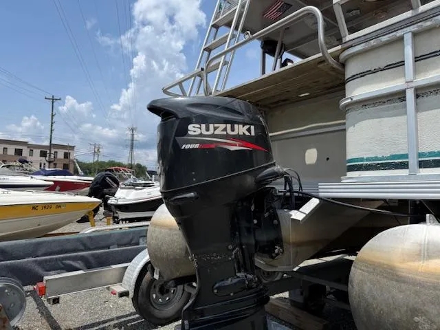Slide: The Image of 1998 Crest III 25 pontoon boat with Suzuki outboard motor in a marina. - 14