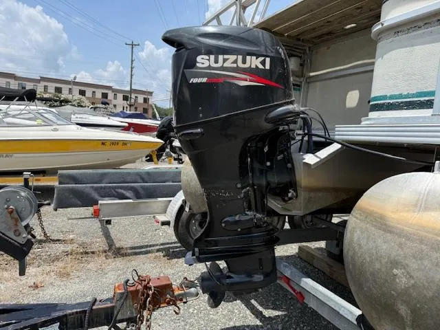 Slide: The Image of Suzuki outboard motor on a 1998 Crest III 25 pontoon boat, parked on a trailer. - 15