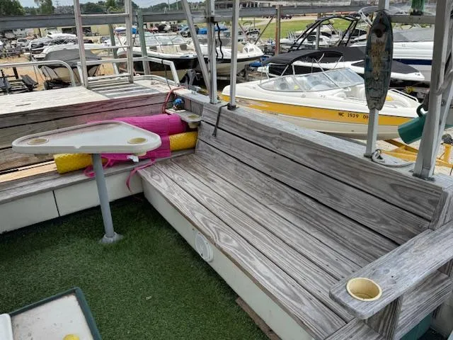 Slide: The Image of Wooden seating area on a 1998 Crest III 25 boat, docked with other boats. - 6