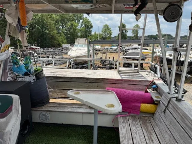 Slide: The Image of Pontoon boat interior with seating, table, and docked boats in the background. - 7