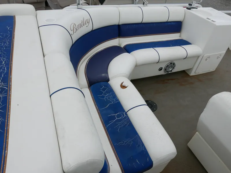 Slide: The Image of 2006 Bentley Pontoons 240 CRUISE interior with blue and white seating, showing wear and tear. - 11