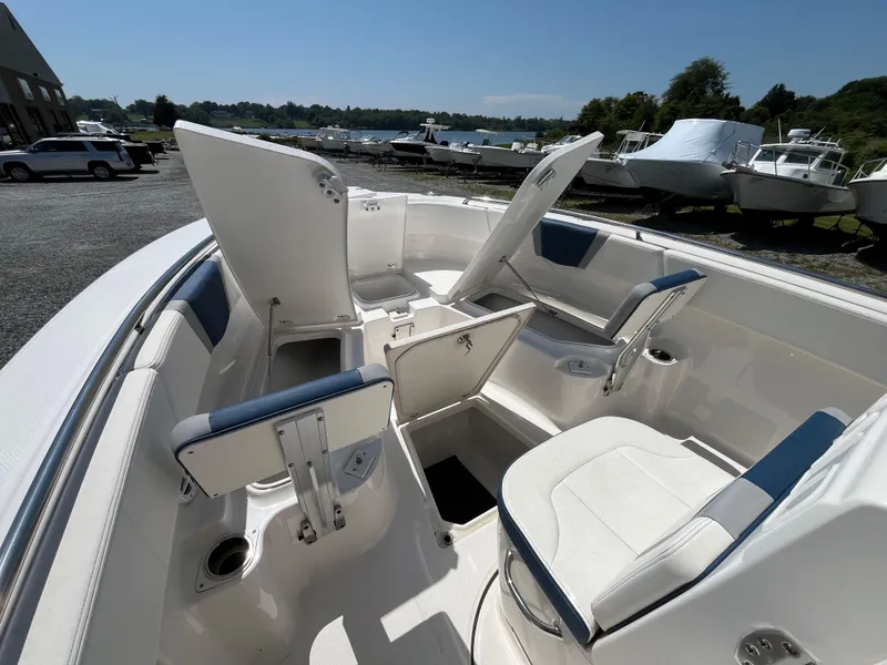Slide: The Image of 2024 Robalo R250 Center Console boat interior with open storage compartments and seating. - 11