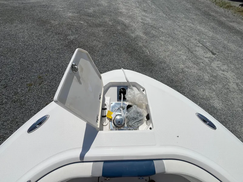 Slide: The Image of 2024 Robalo R250 Center Console boat anchor compartment open on deck. - 12