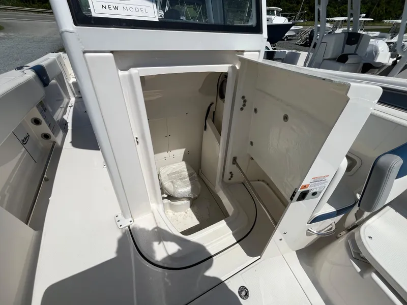 Slide: The Image of 2024 Robalo R250 Center Console boat with open cabin door revealing interior space. - 14