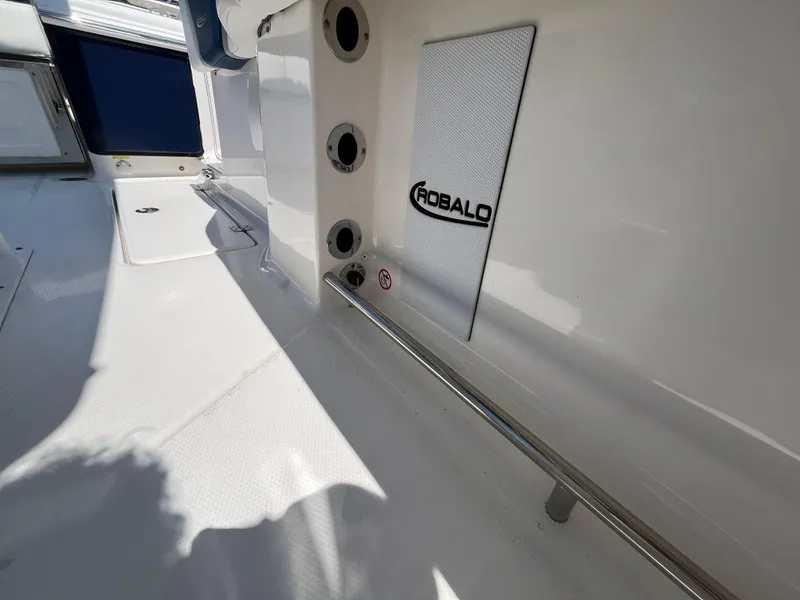 Slide: The Image of 2024 Robalo R250 Center Console interior with rod holders and branded panel. - 9
