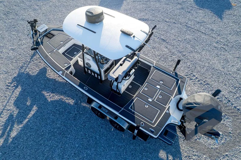 Slide: The Image of 2026 Pathfinder 2300 HPS boat, aerial view, sleek design on gravel surface. - 123