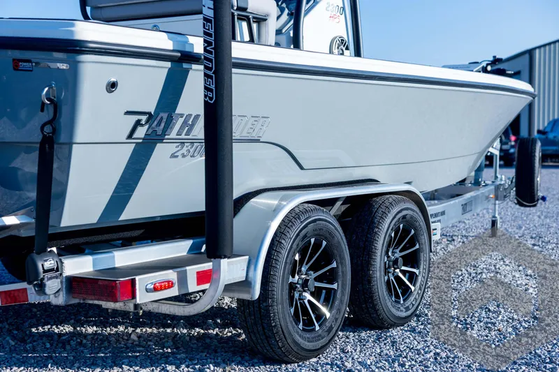 Slide: The Image of 2026 Pathfinder 2300 HPS boat on trailer, featuring sleek design and dual axles. - 18