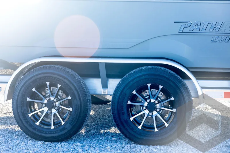Slide: The Image of 2026 Pathfinder 2300 HPS trailer wheels on gravel, sunlight reflection. - 36