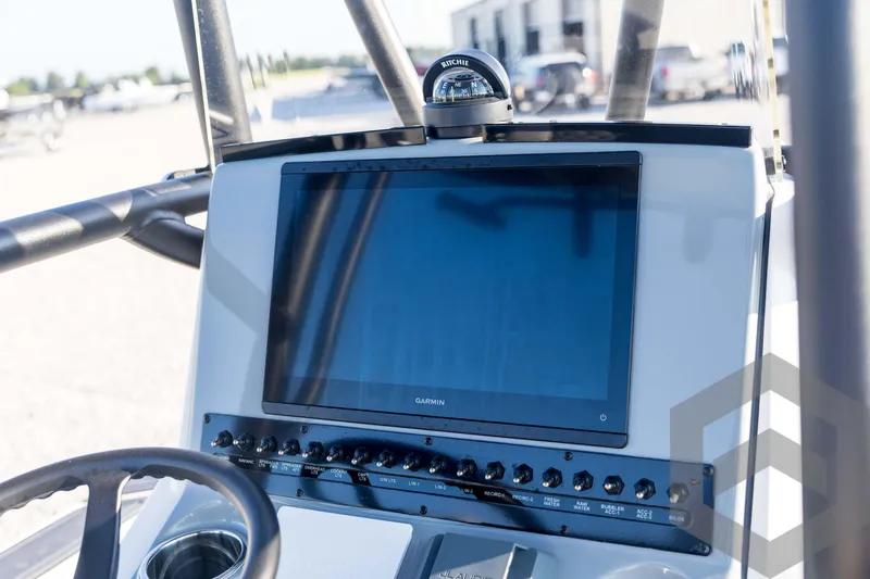 Slide: The Image of 2026 Pathfinder 2300 HPS boat dashboard with Garmin display and Ritchie compass. - 82