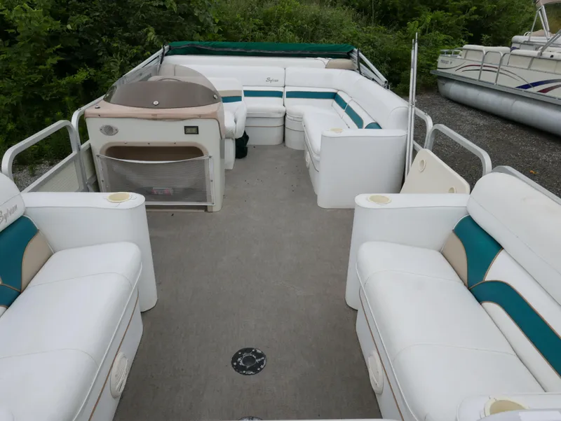 Slide: The Image of 1996 Sylvan 820 Cruise Special Edition pontoon boat with white seating and teal accents. - 4