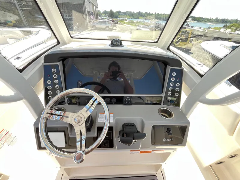 Slide: The Image of 2024 Robalo R270 Center Console boat interior with storage compartments and twin engines. - 10