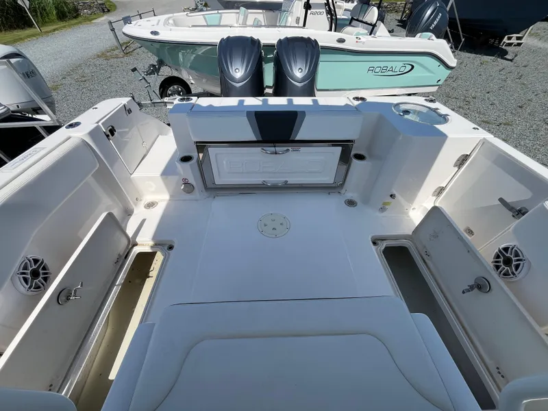 Slide: The Image of 2024 Robalo R270 Center Console boat interior with open storage compartments and seating. - 12