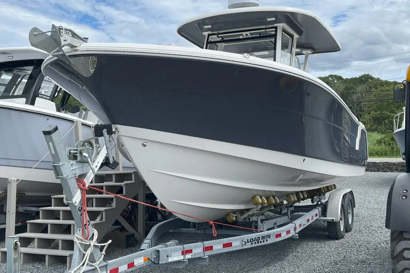 The Image of 2024 Robalo R302 Center Console boat on trailer, parked outdoors. - 0