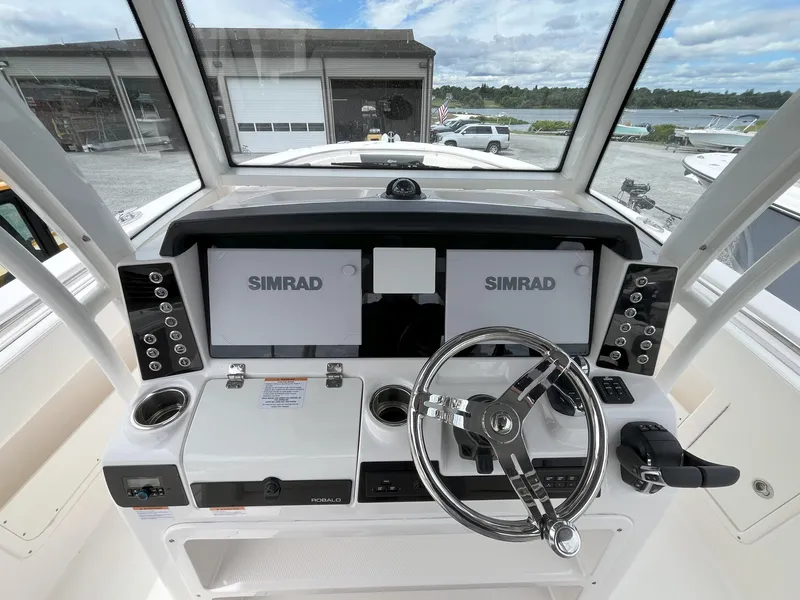 Slide: The Image of 2024 Robalo R302 Center Console boat displayed in a dealership lot. - 5