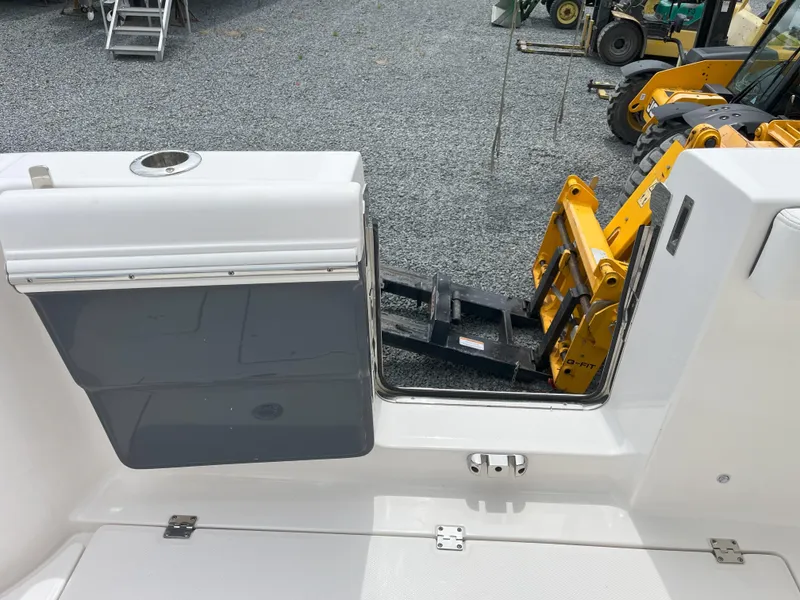 Slide: The Image of 2024 Robalo R302 Center Console boat with open storage compartments, displayed in a marina. - 8