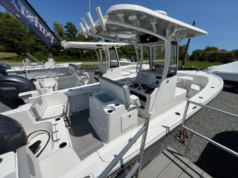 Slide: The Image of 2024 Parker 2400 Center Console boat with modern helm and seating, docked outdoors. - 2