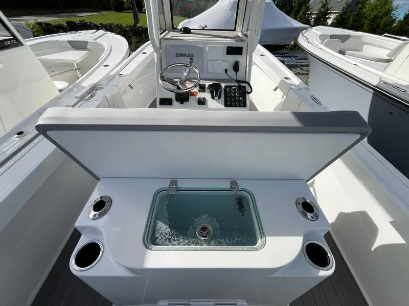 Slide: The Image of Storage compartment with tackle boxes on a 2024 Parker 2400 Center Console boat. - 5