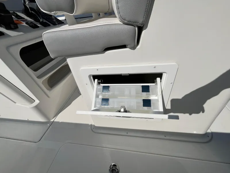 Slide: The Image of 2024 Parker 2600 Center Console boat with open storage compartment and cushioned seating. - 12