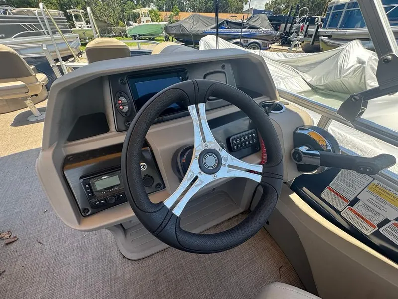 Slide: The Image of 2024 Sun Tracker Fishin' Barge 22 DLX steering console with modern controls and dashboard. - 5