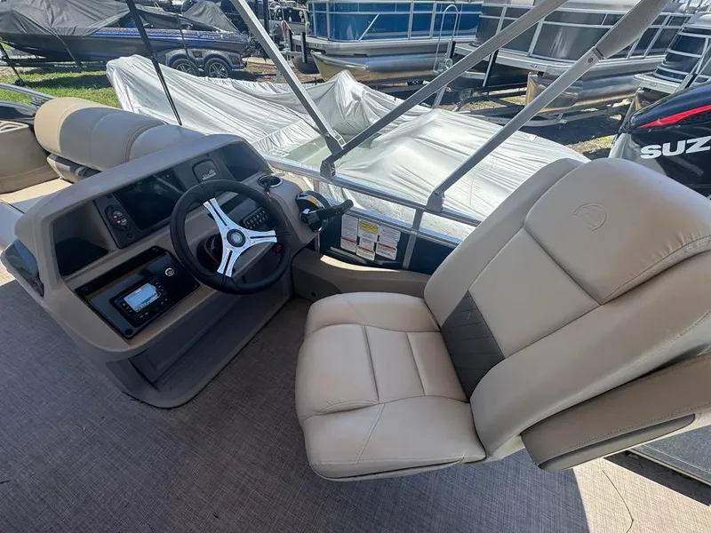 Slide: The Image of 2024 Sun Tracker Fishin' Barge 22 DLX helm with comfortable seating and modern controls. - 7