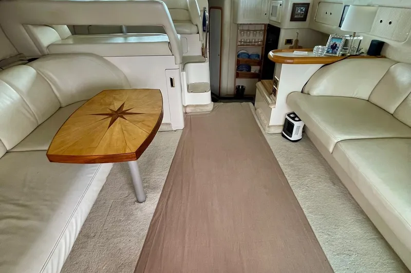 Slide: The Image of Luxurious interior of a 1997 Sea Ray 400 Sedan Bridge with elegant seating and wooden table. - 10