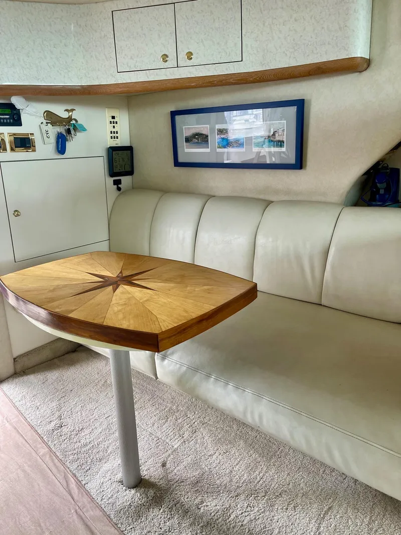 Slide: The Image of Interior of 1997 Sea Ray 400 Sedan Bridge with elegant seating and wooden table. - 11