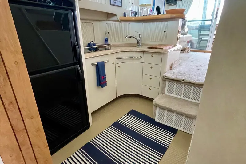 Slide: The Image of Interior of 1997 Sea Ray 400 Sedan Bridge yacht kitchen with striped rug and stairs. - 14