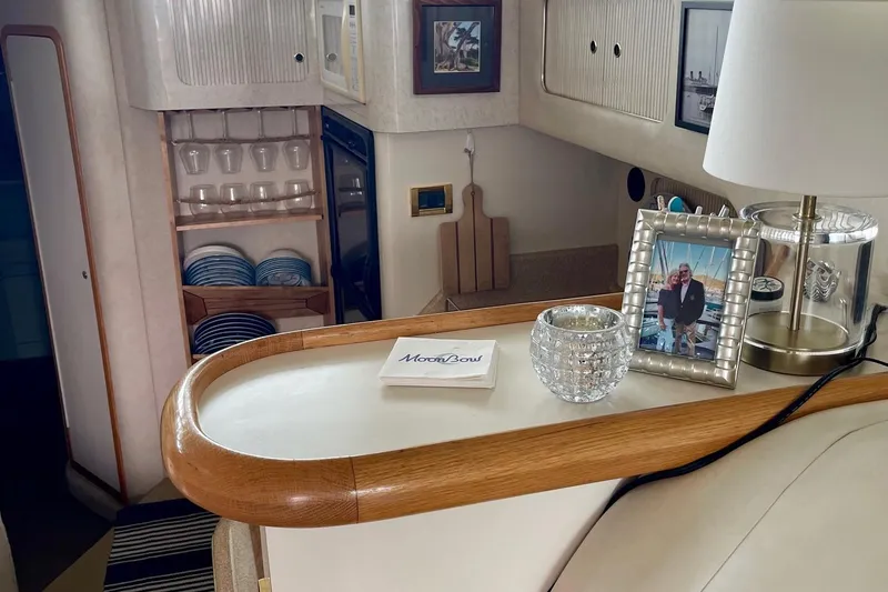 Slide: The Image of Interior of 1997 Sea Ray 400 Sedan Bridge with decor and dining setup. - 15