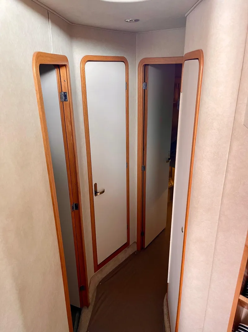 Slide: The Image of Interior hallway of 1997 Sea Ray 400 Sedan Bridge with wooden door frames. - 16