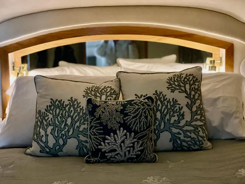 Slide: The Image of Luxurious bedding with coral-themed pillows on a 1997 Sea Ray 400 Sedan Bridge yacht. - 17