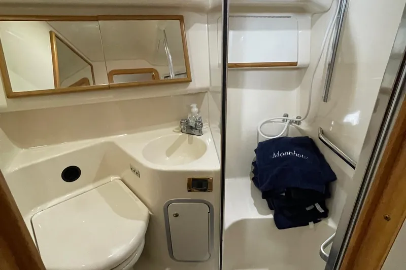 Slide: The Image of 1997 Sea Ray 400 Sedan Bridge bathroom with sink, mirror, and shower area. - 19