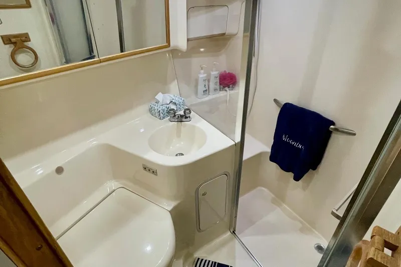 Slide: The Image of Bathroom interior of 1997 Sea Ray 400 Sedan Bridge yacht, featuring sink and shower. - 21