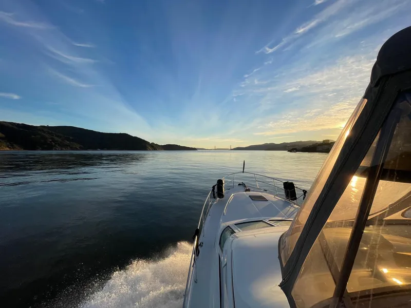 Slide: The Image of 1997 Sea Ray 400 Sedan Bridge cruising on serene waters at sunset. - 22