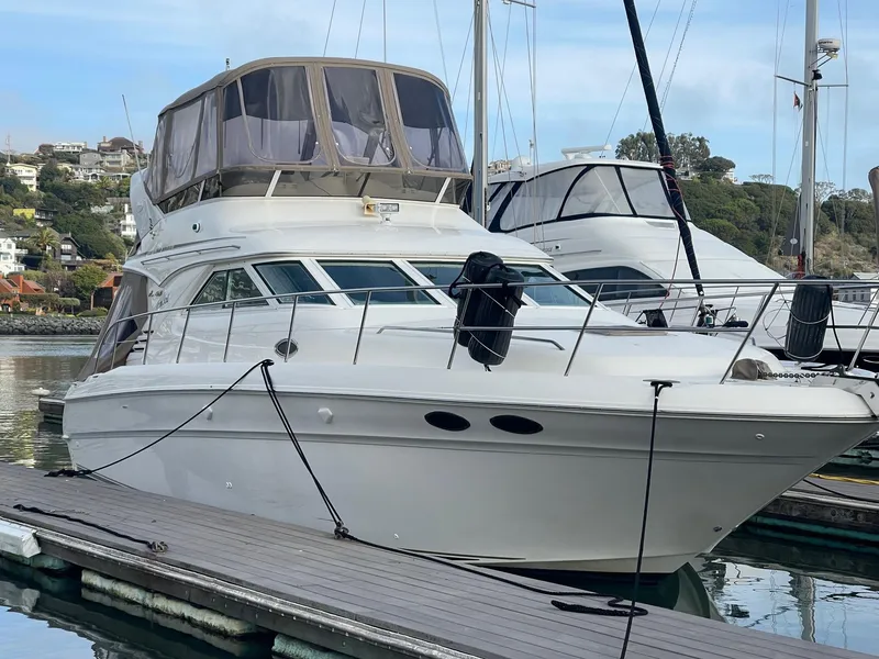 Slide: The Image of 1997 Sea Ray 400 Sedan Bridge yacht docked at marina, featuring sleek design and spacious cabin. - 4