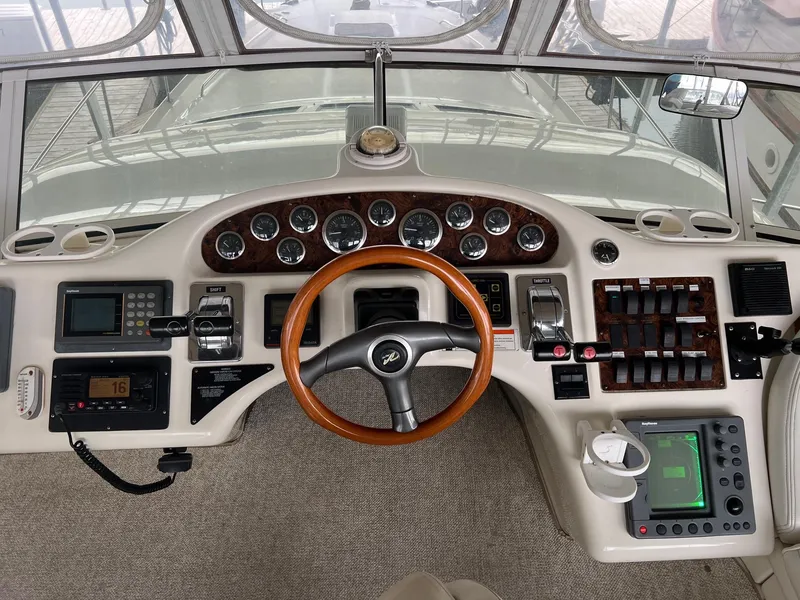 Slide: The Image of 1997 Sea Ray 400 Sedan Bridge helm with wood accents and modern navigation controls. - 7