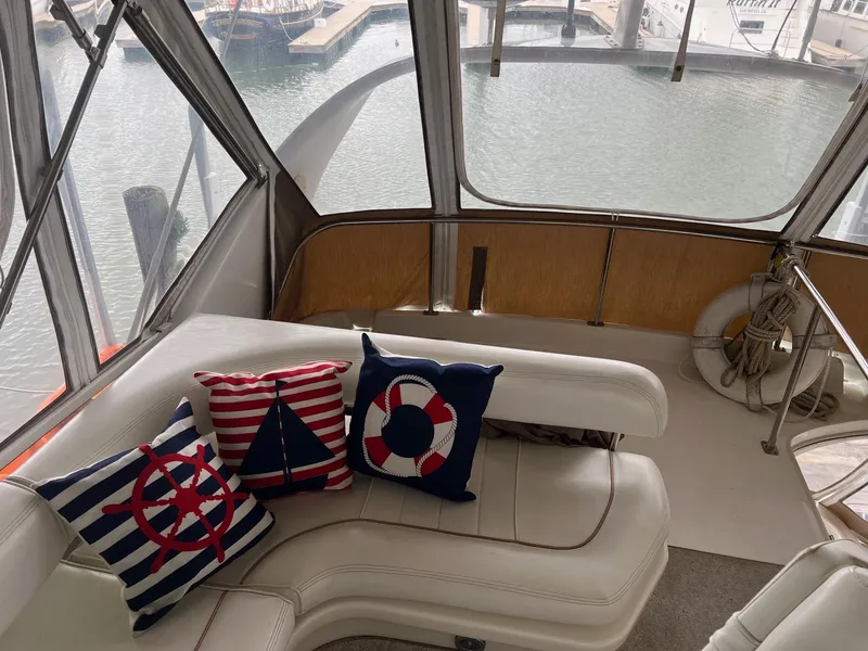 Slide: The Image of Interior of 1997 Sea Ray 400 Sedan Bridge with nautical-themed cushions and marina view. - 8