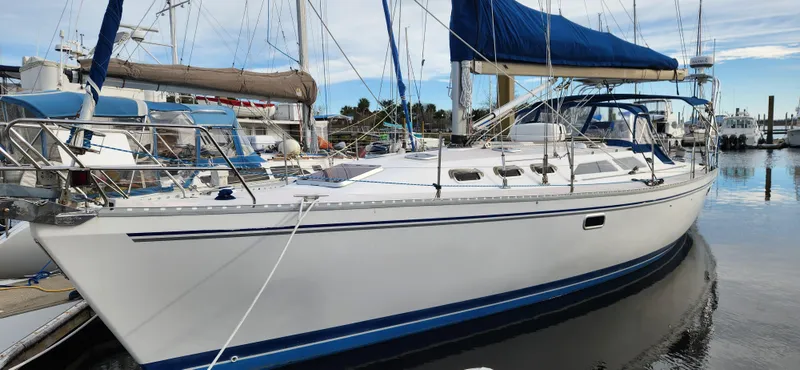 The Image of 1998 Catalina 400 sailboat docked at marina, featuring sleek white hull and blue sail cover. - 0