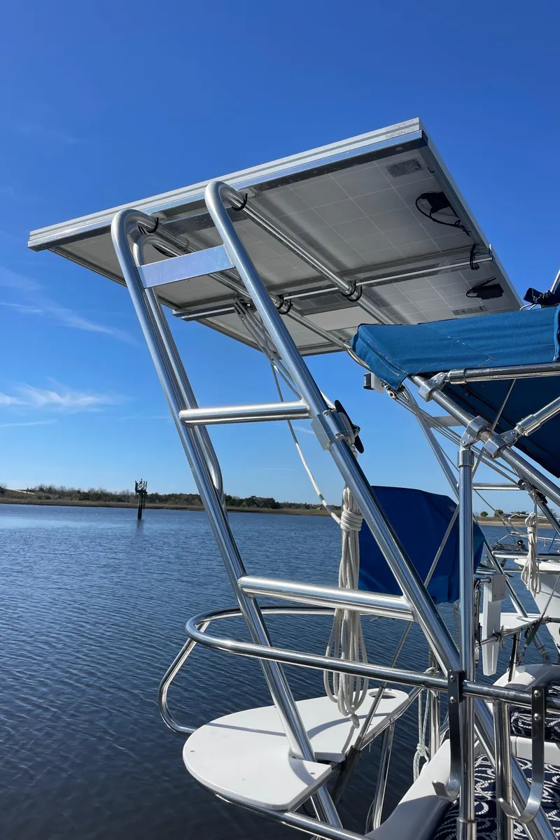Slide: The Image of Sailboat with solar panel, Catalina 400, 1998 model, on calm water under clear blue sky. - 11
