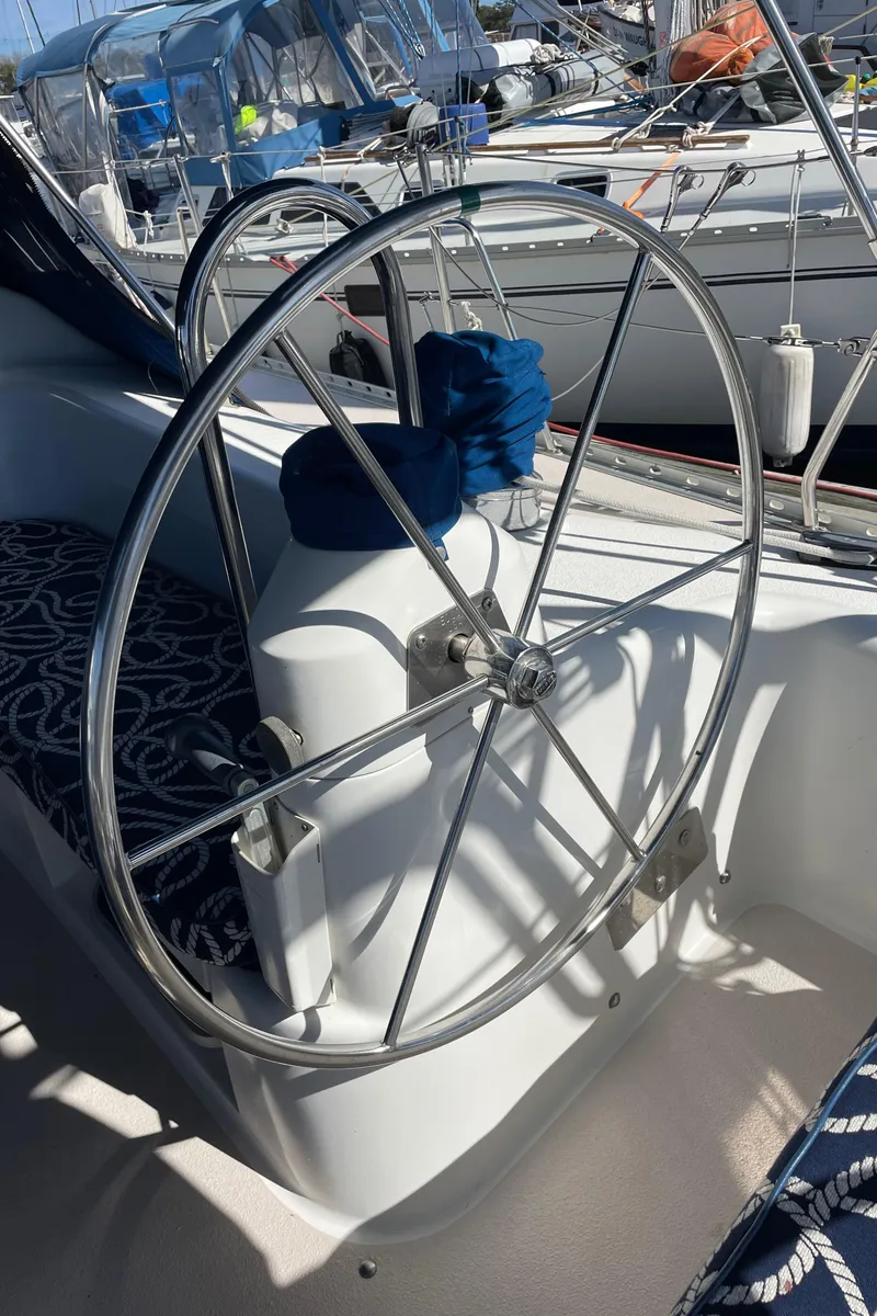 Slide: The Image of Steering wheel of a 1998 Catalina 400 sailboat, docked with other boats. - 25