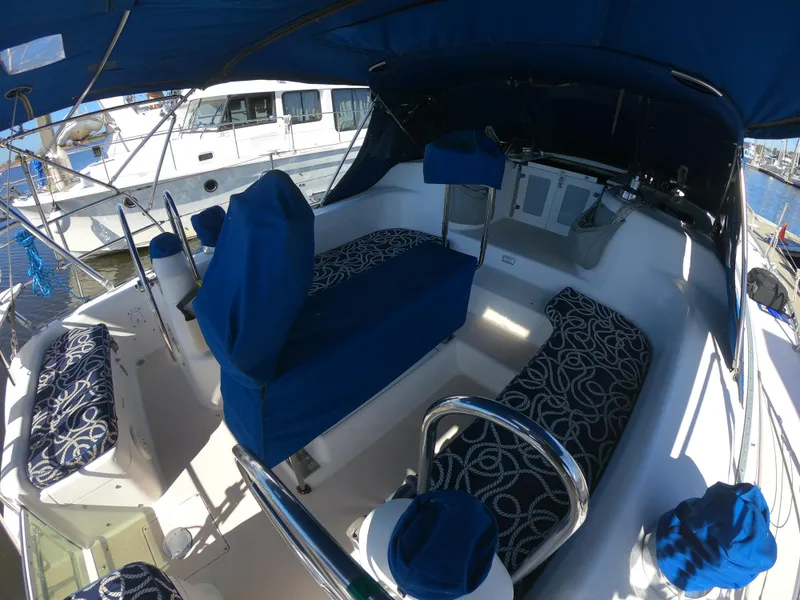 Slide: The Image of 1998 Catalina 400 sailboat cockpit with blue and white patterned seating, docked at marina. - 27