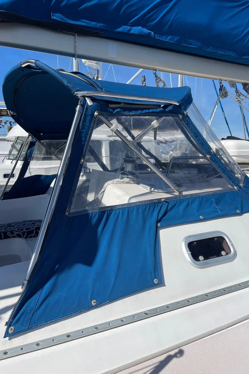 Slide: The Image of 1998 Catalina 400 sailboat with blue canvas cover and clear windows in a marina setting. - 38