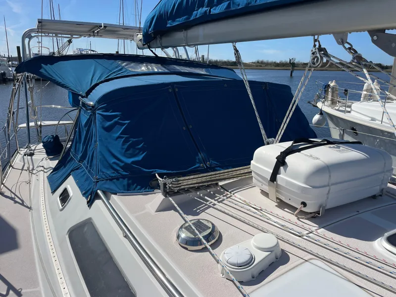 Slide: The Image of 1998 Catalina 400 sailboat with blue canopy and deck equipment, docked at marina. - 39