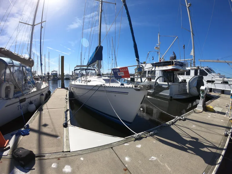 Slide: The Image of Catalina 400 sailboat from 1998 docked at marina, sunny day, "For Sale" sign visible. - 4