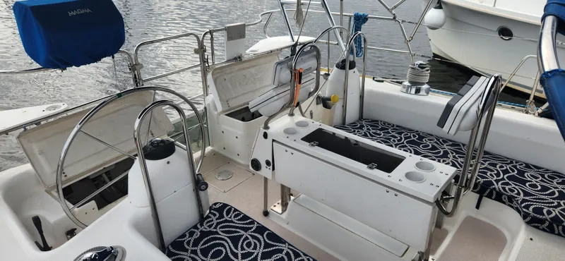 Slide: The Image of 1998 Catalina 400 sailboat cockpit with open storage, patterned cushions, and dual steering wheels. - 46