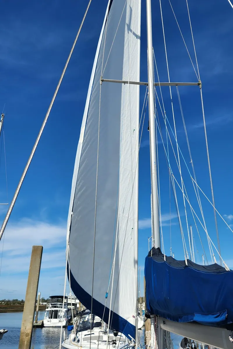 Slide: The Image of Sailboat with tall mast and blue sail cover, Catalina 400, 1998 model, docked under clear sky. - 6