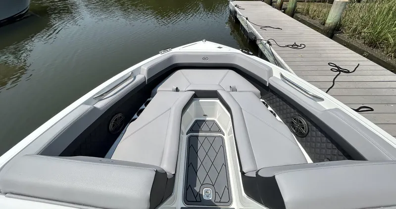 Slide: The Image of 2026 Cobalt R4 boat interior with gray seating, docked by a wooden pier. - 15