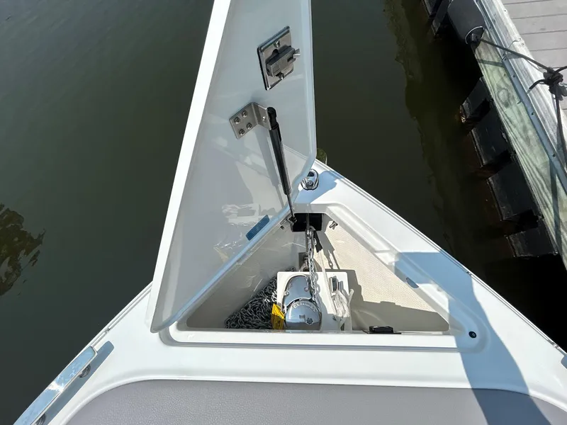 Slide: The Image of 2026 Cobalt R4 boat anchor compartment with open hatch, dockside view. - 17
