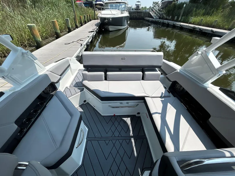 Slide: The Image of 2026 Cobalt R4 boat interior with sleek seating, docked by a wooden pier. - 6